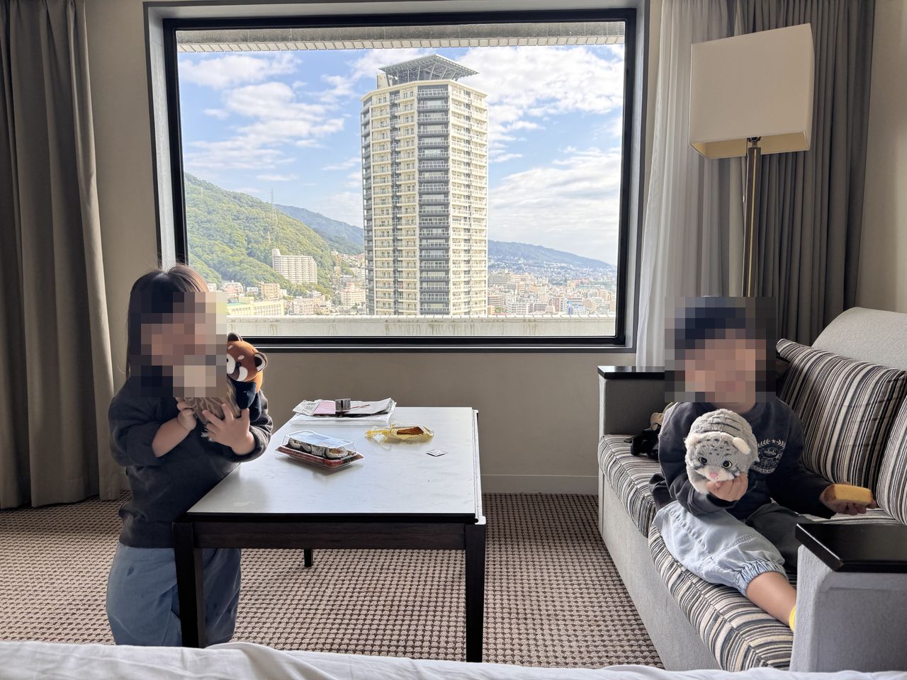 兩個孩子在 ANA 皇冠假日酒店房間的窗邊沙發玩耍